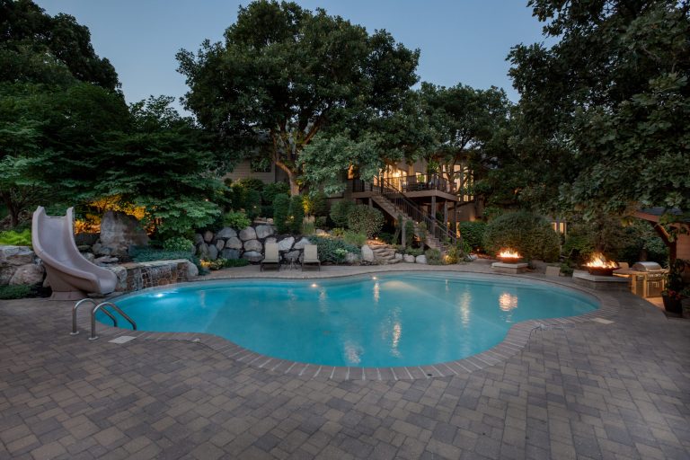 Inspiration for a timeless backyard concrete paver and custom-shaped water slide remodel in Omaha