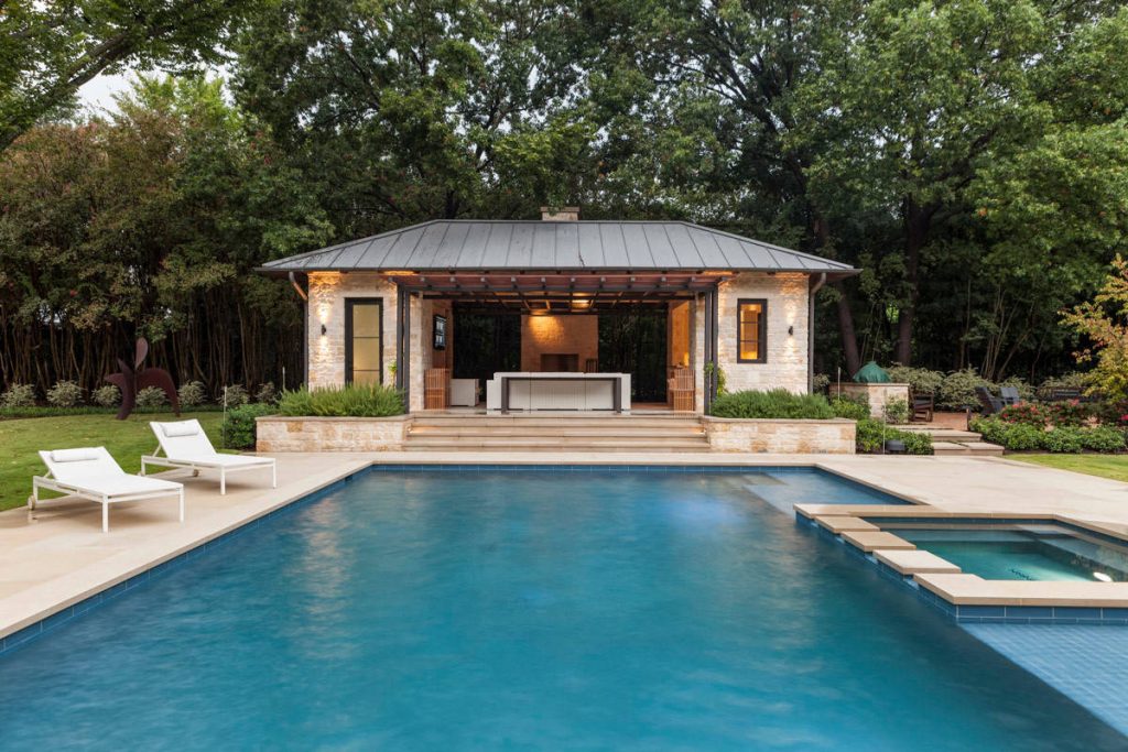 Inspiration for a transitional backyard stone and custom-shaped pool house remodel in Dallas