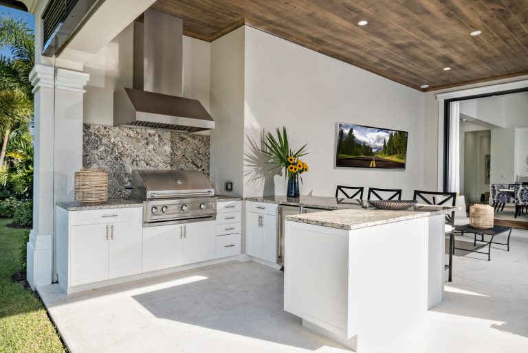 Inspiration for a transitional backyard stone patio kitchen remodel in Miami with a roof extension
