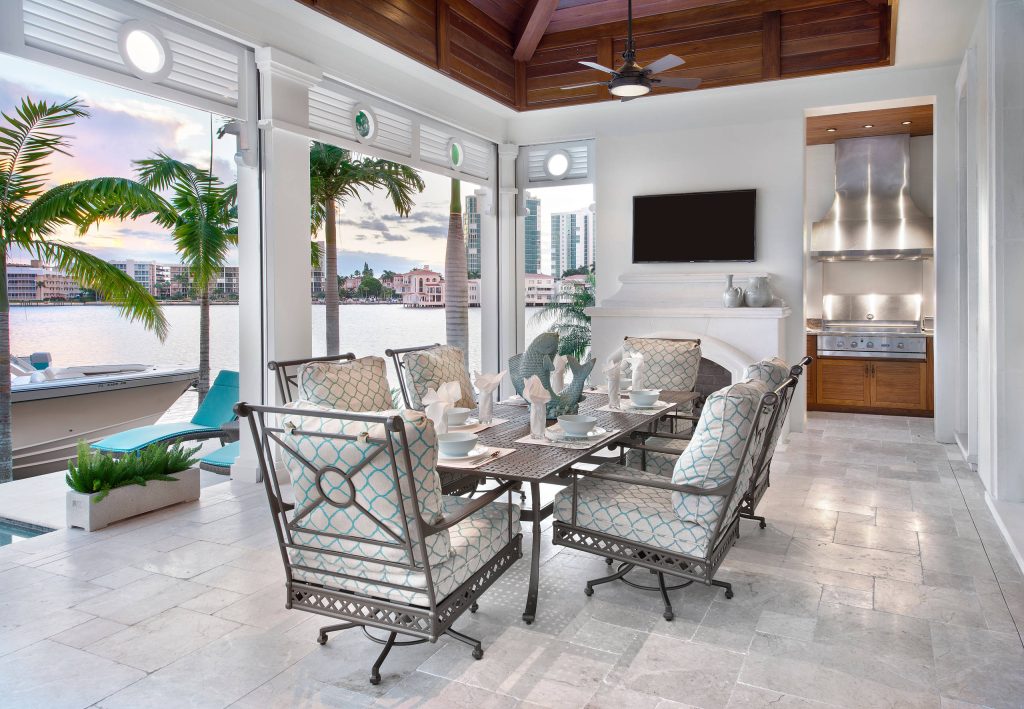 Inspiration for a tropical backyard patio kitchen remodel in Miami with a roof extension