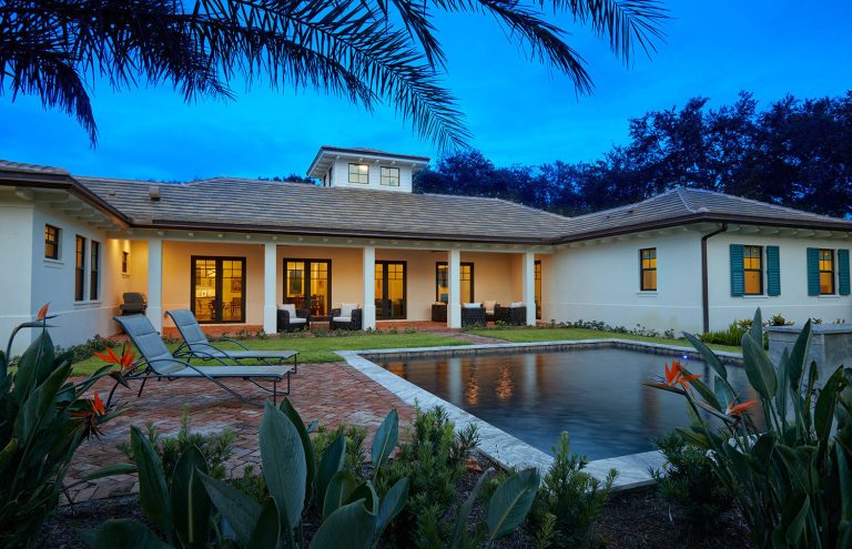 Island style backyard brick and rectangular pool photo in Miami