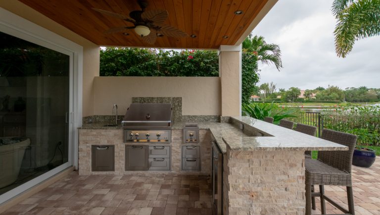 Island style backyard brick patio kitchen photo in Miami with a roof extension