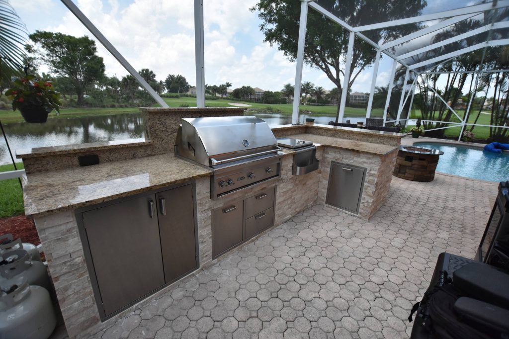 Island style backyard brick patio kitchen photo in Miami with no cover