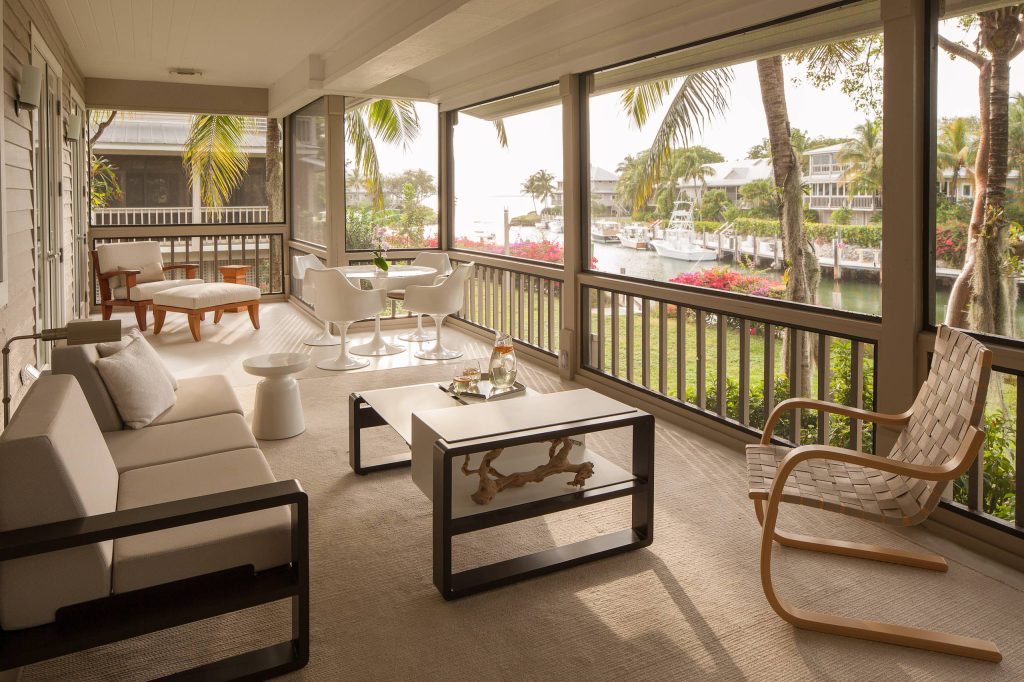 Island style screened-in porch idea in Miami with a roof extension by Michael Wolk Design Associates | Outdoor Photos | Porch | Landscaping | Landscape Design | Outdoor Living Space | Porch Design Ideas | Outdoor Living Space Ideas | Backyard Design