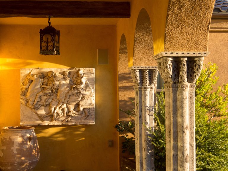 John Connell photo. Covered patio with carved stone columns.