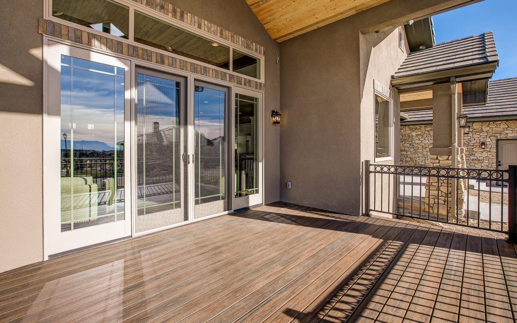 Large arts and crafts backyard deck photo in Denver with a roof extension