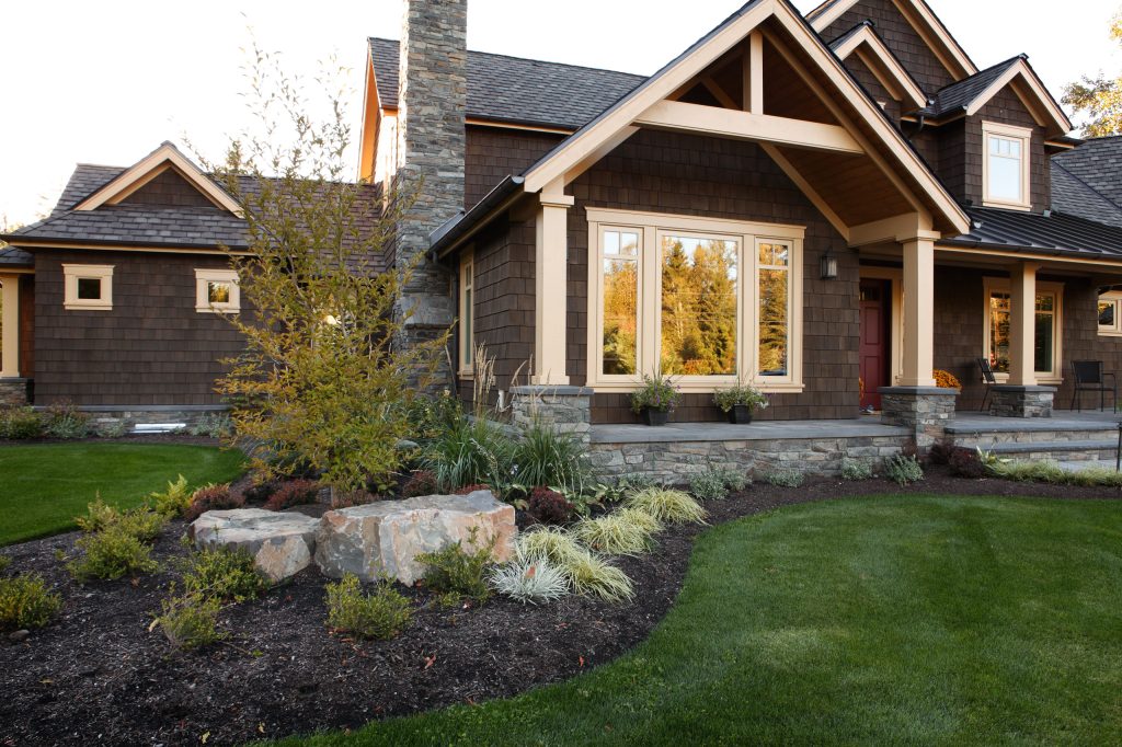 Large arts and crafts stone back porch photo in Seattle with an awning by Alderwood Landscape Architecture and Construction | Outdoor Photos | Porch | Landscaping | Landscape Design | Outdoor Living Space | Porch Design Ideas | Outdoor Living Space Ideas | Backyard Design