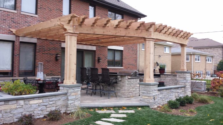 Large backyard brick patio kitchen photo in Chicago with a pergola