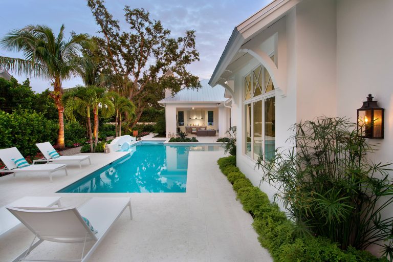 Large beach style backyard tile and custom-shaped pool photo in Other