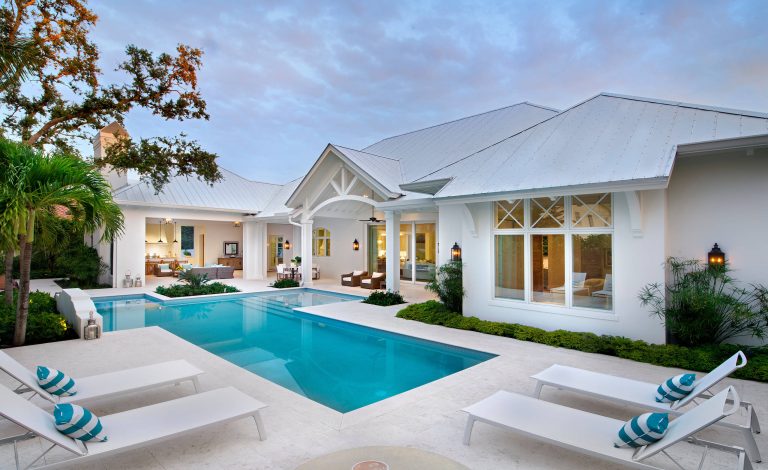 Large beach style backyard tile and custom-shaped pool photo in Other