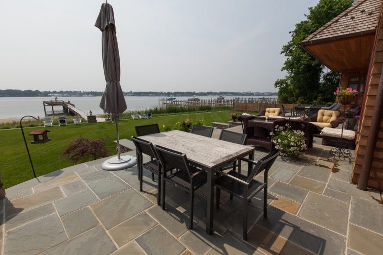 Large beach style backyard tile patio kitchen photo in New York with a roof extension