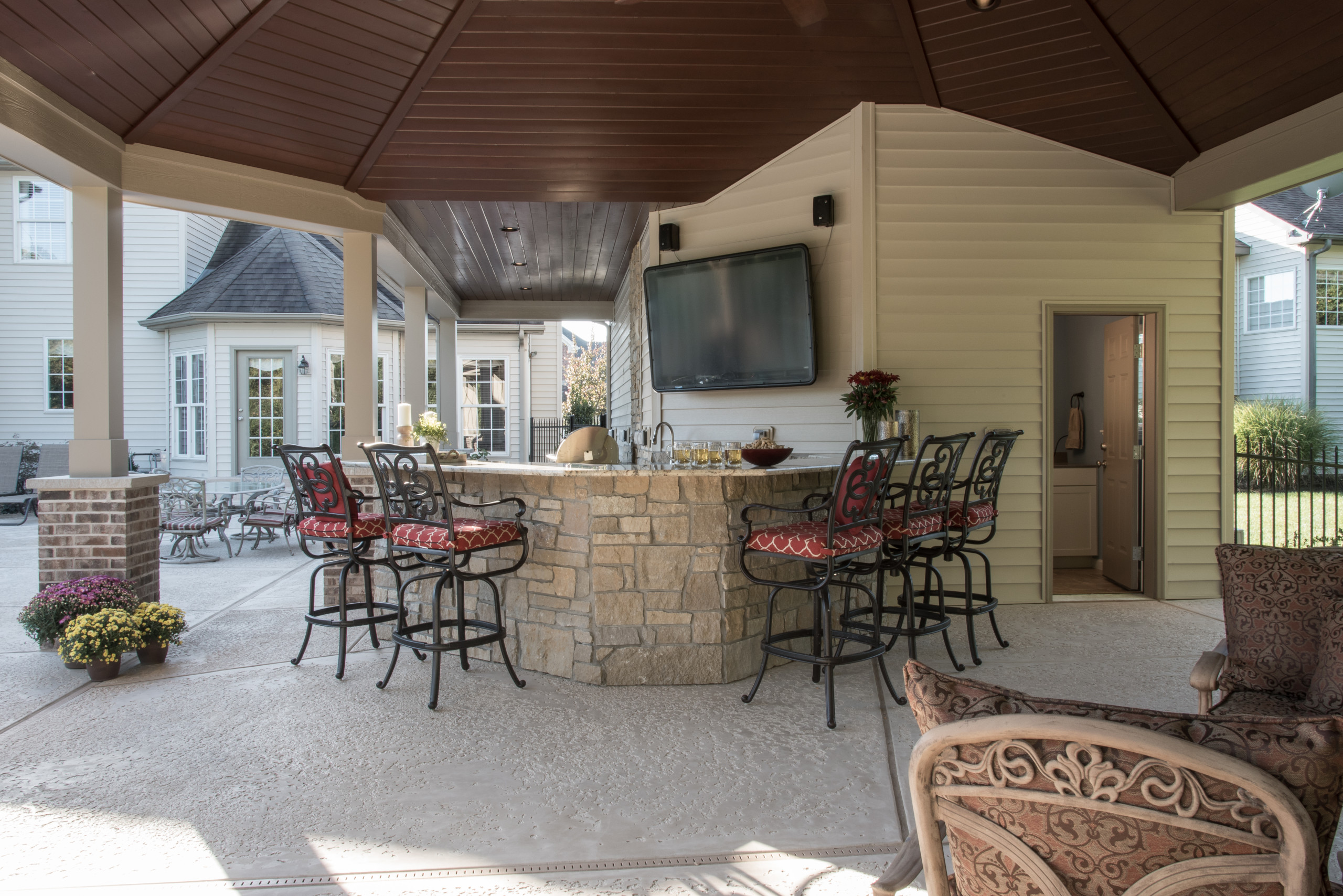 Large classic stamped concrete porch idea in St Louis with a roof extension