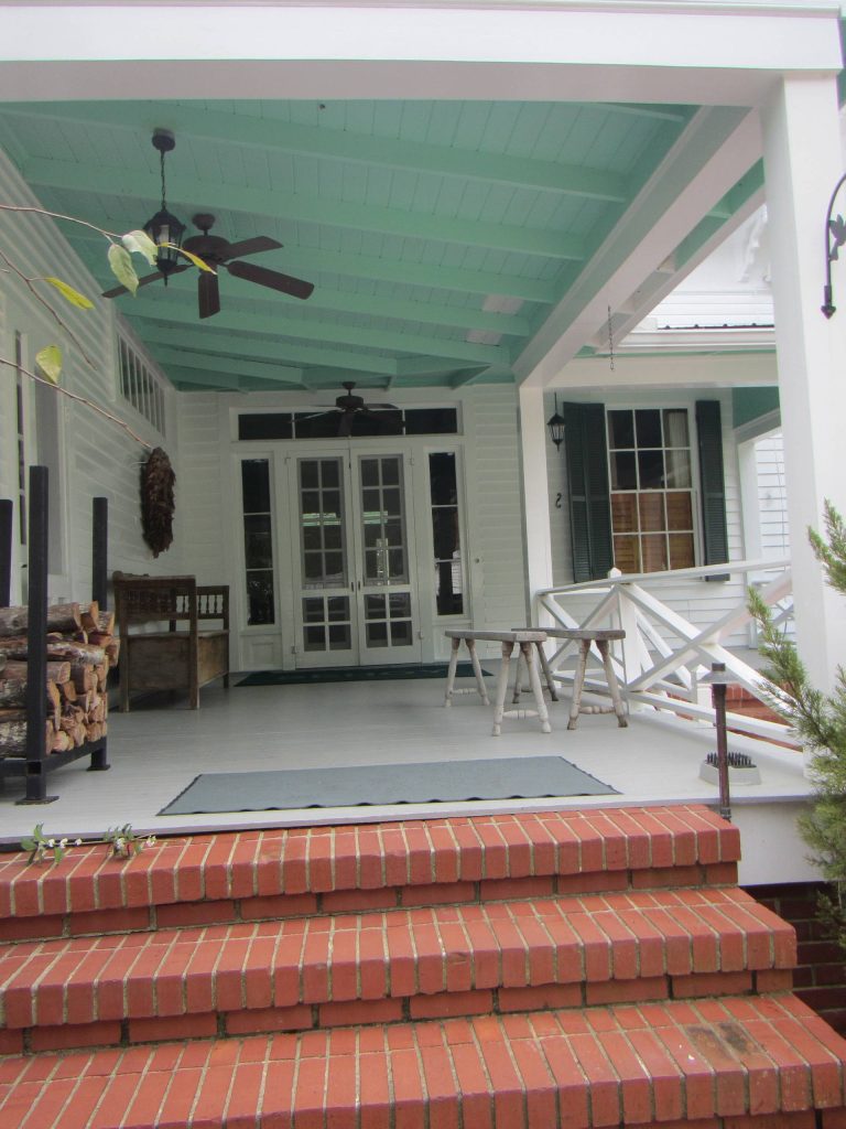 Large cottage brick front porch photo in Atlanta with a roof extension by CertaPro Painters of Columbus, GA - Auburn, AL | Outdoor Photos | Porch | Landscaping | Landscape Design | Outdoor Living Space | Porch Design Ideas | Outdoor Living Space Ideas | Backyard Design