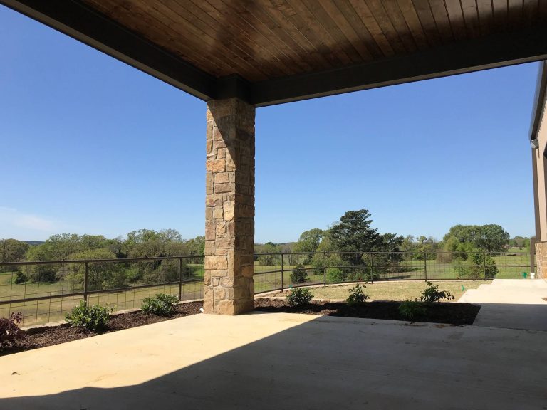 Large country backyard concrete patio kitchen photo in Dallas with a roof extension