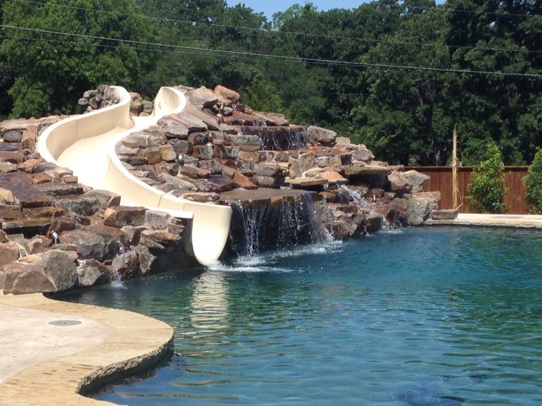 Large custom waterfall with custom slide. Large diving pool with beach entry and spa.