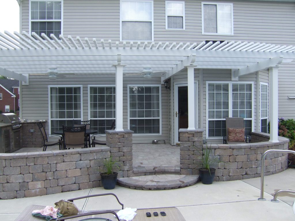 Large elegant backyard concrete patio kitchen photo in Other with a pergola