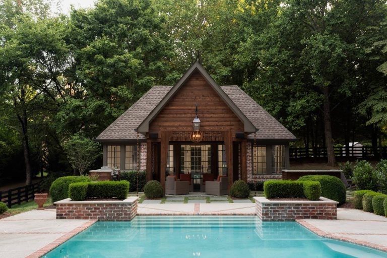 Large elegant backyard concrete paver and custom-shaped pool house photo in Nashville