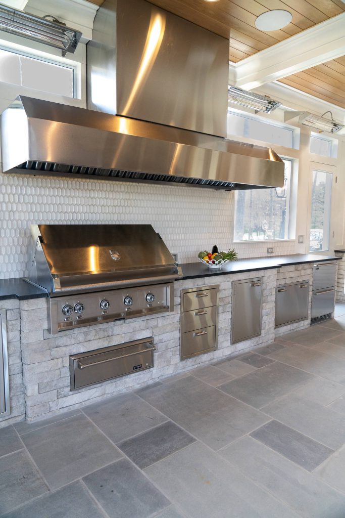 Large elegant backyard concrete paver patio kitchen photo in DC Metro with a roof extension