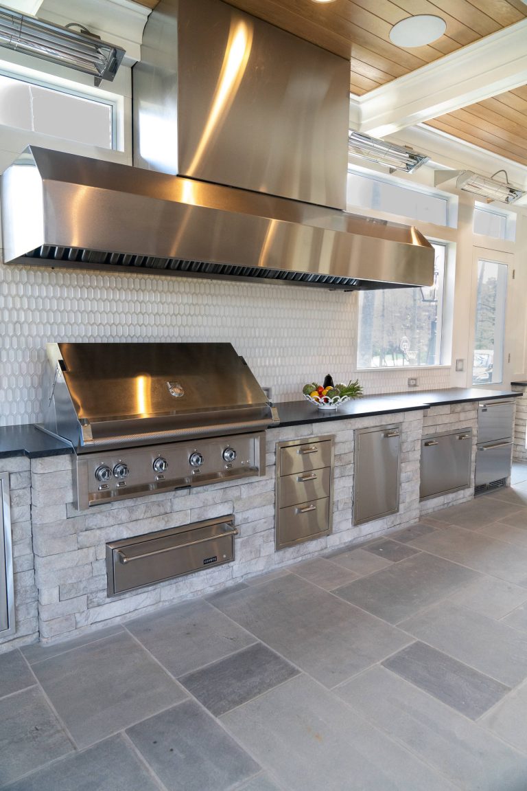 Large elegant backyard concrete paver patio kitchen photo in DC Metro with a roof extension