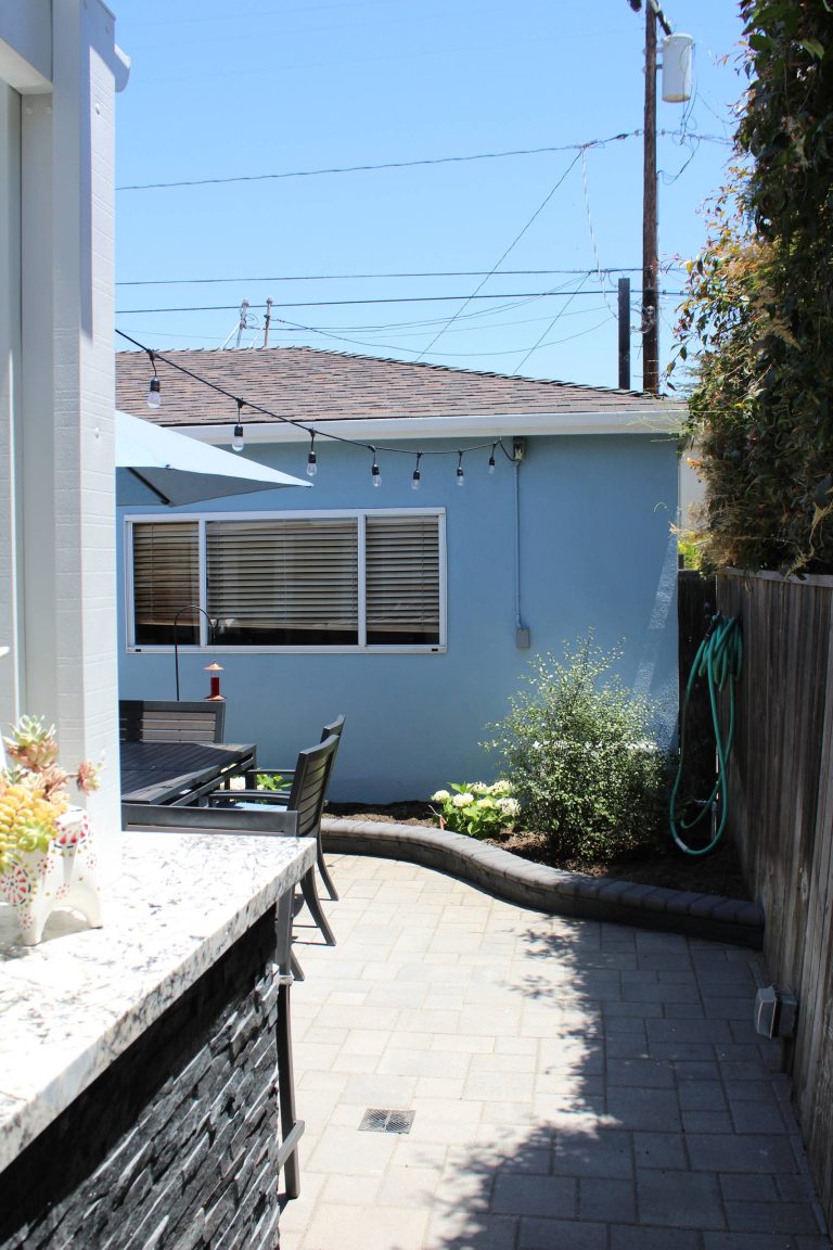 Large elegant backyard concrete paver patio kitchen photo in Los Angeles with a pergola