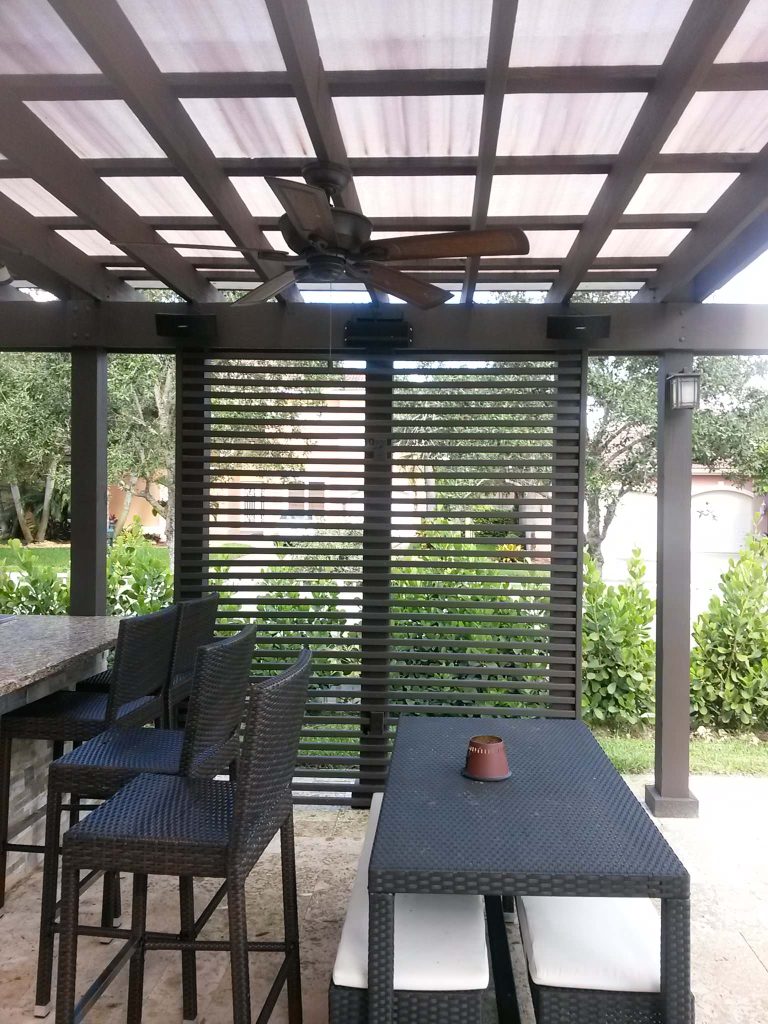 Large elegant backyard concrete paver patio kitchen photo in Miami with a pergola