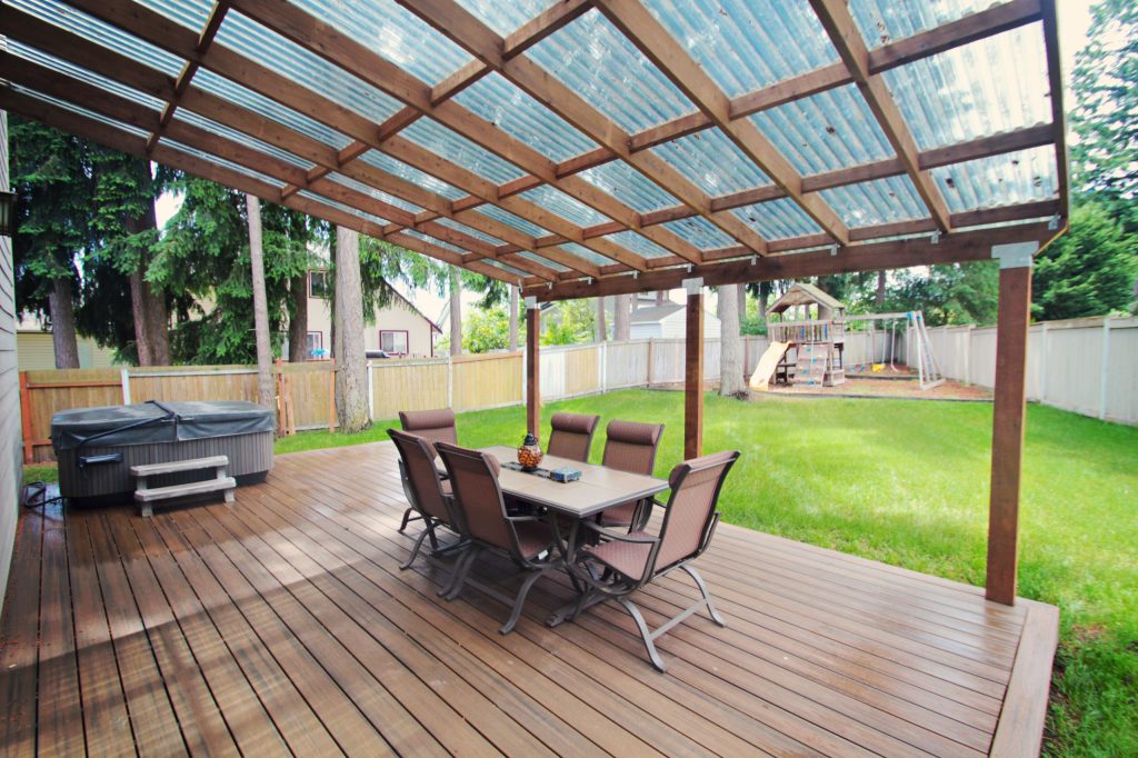 Large elegant backyard deck photo in Seattle with a roof extension