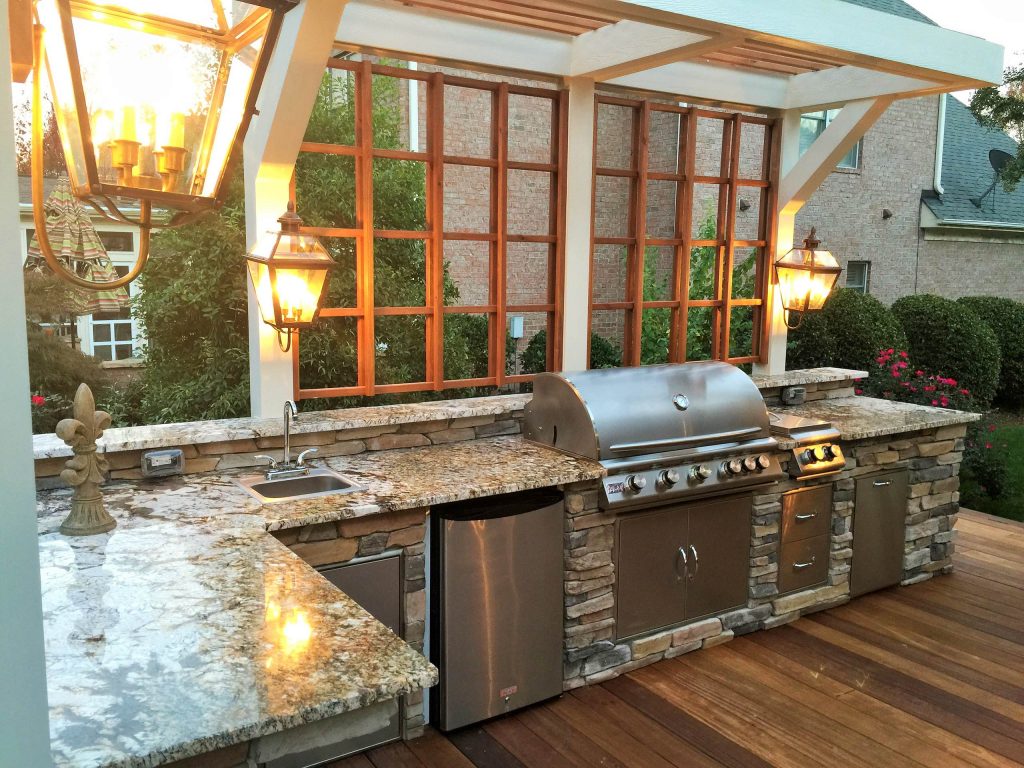 Large elegant backyard patio kitchen photo in Charlotte with decking and a pergola