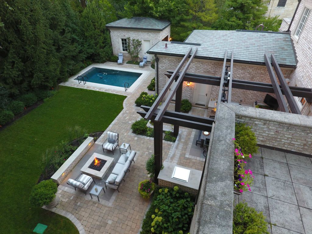 Large elegant backyard stone patio kitchen photo in Chicago with a pergola