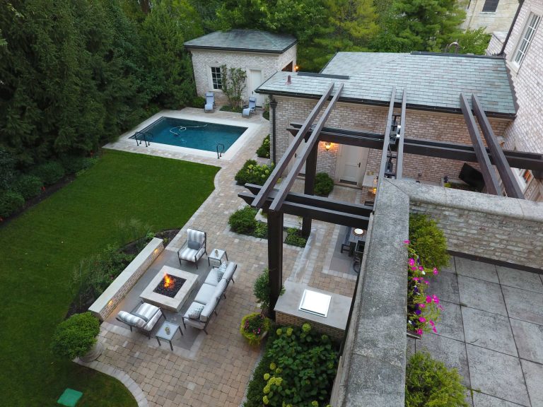Large elegant backyard stone patio kitchen photo in Chicago with a pergola