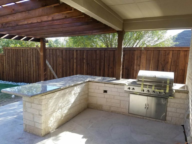 Large elegant backyard stone patio kitchen photo in Dallas with no cover
