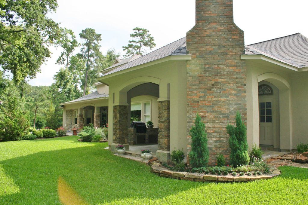 Large elegant backyard stone patio kitchen photo in Houston with a gazebo