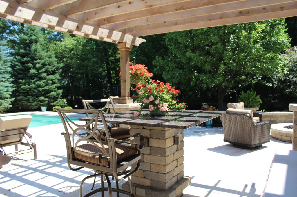 Large elegant backyard stone patio kitchen photo in Indianapolis with a pergola