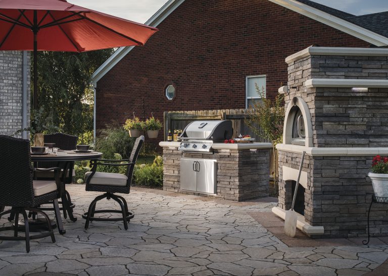Large elegant backyard stone patio kitchen photo in New York with no cover