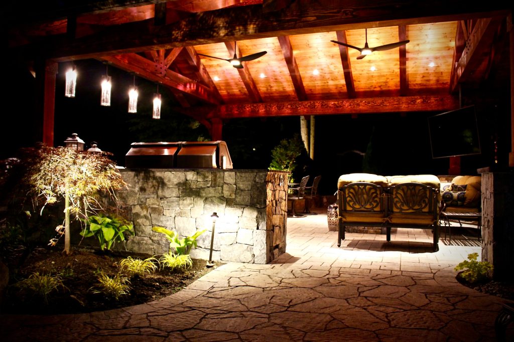 Large elegant backyard stone patio kitchen photo in Seattle with a gazebo