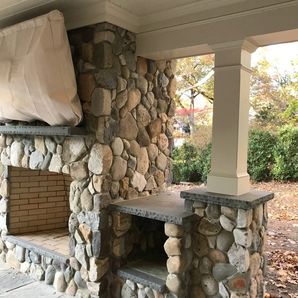 Large elegant tile porch photo in New York with a roof extension