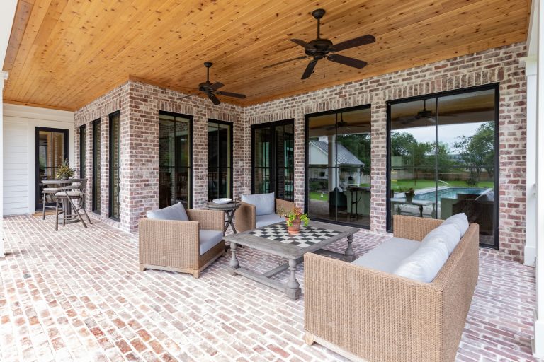 Large farmhouse brick back porch photo in Houston with a roof extension by Stone Acorn Builders | Outdoor Photos | Porch | Landscaping | Landscape Design | Outdoor Living Space | Porch Design Ideas | Outdoor Living Space Ideas | Backyard Design