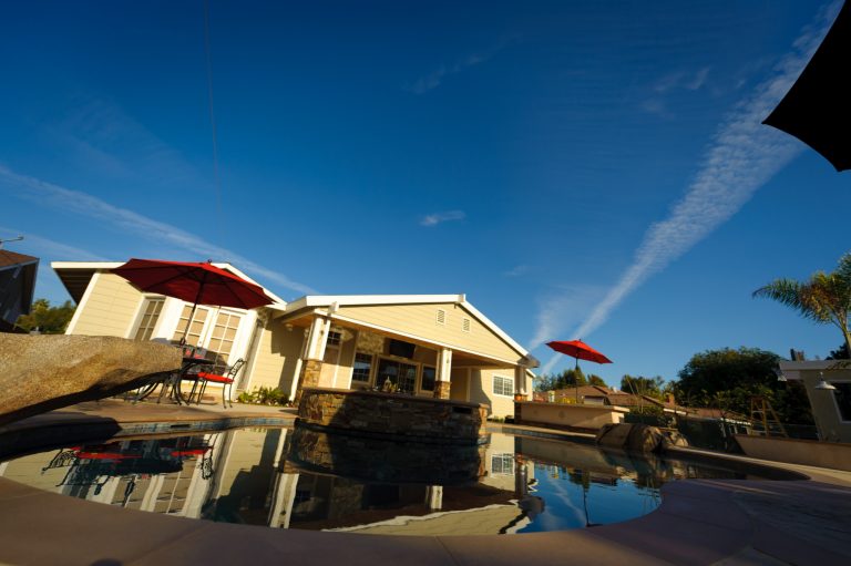 Large island style backyard concrete and custom-shaped natural hot tub photo in Orange County