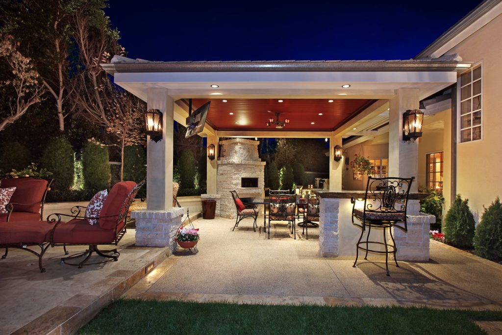 Large island style backyard concrete paver patio kitchen photo in Orange County with a gazebo