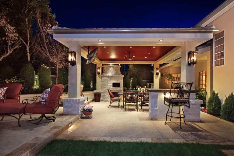 Large island style backyard concrete paver patio kitchen photo in Orange County with a gazebo