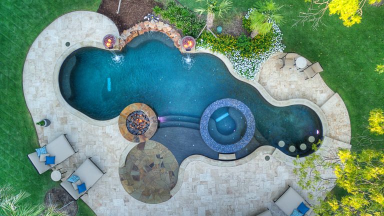Large island style backyard tile and kidney-shaped hot tub photo in Dallas