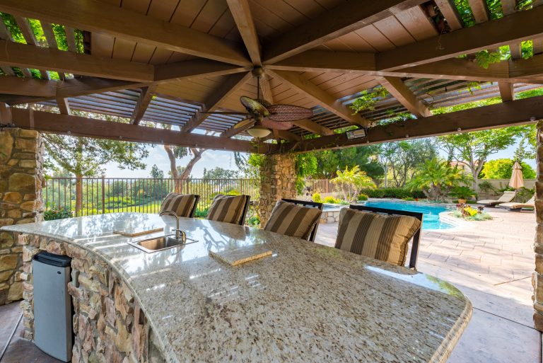 Large mid-century modern backyard stone patio kitchen photo in San Diego with a gazebo