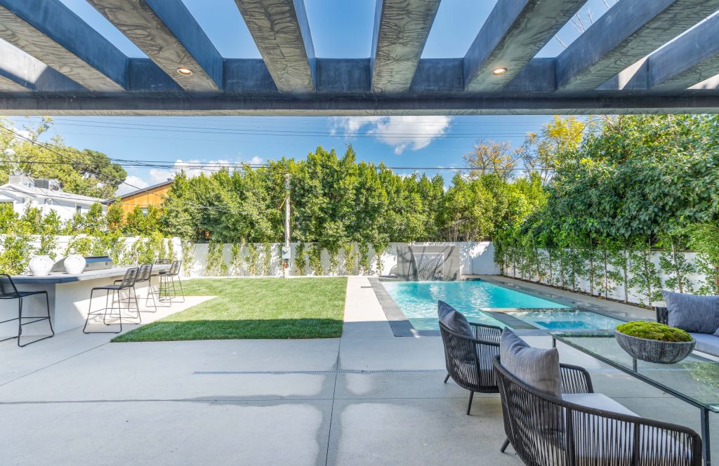 Large minimalist backyard concrete patio kitchen photo in Los Angeles with a pergola