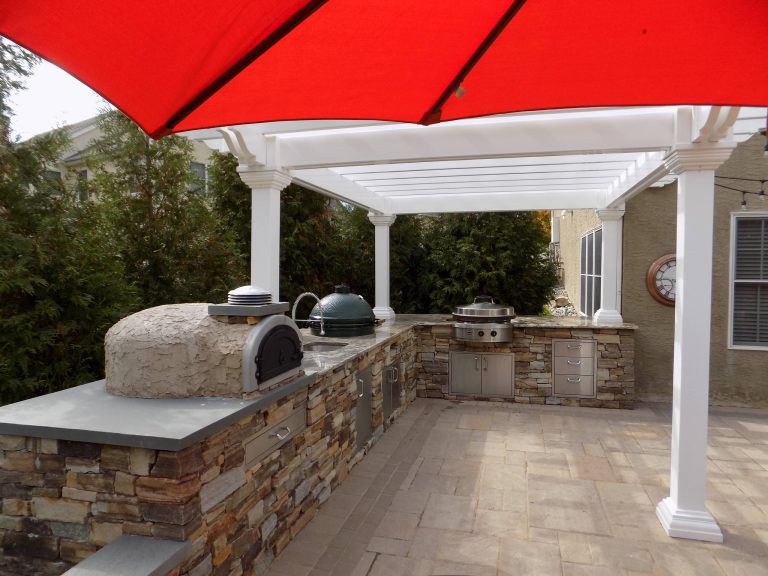 Large minimalist backyard concrete paver patio kitchen photo in Philadelphia with a pergola