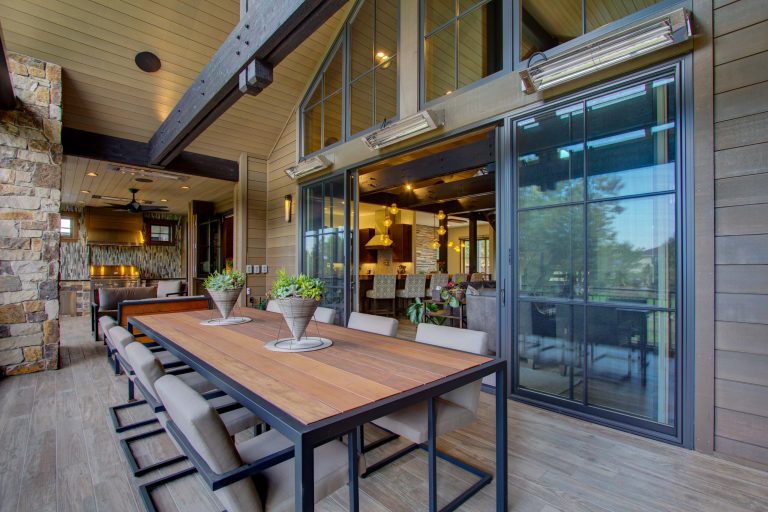 Large minimalist backyard outdoor kitchen deck photo in Denver with a roof extension