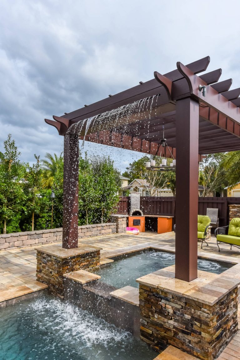 Large minimalist backyard stone and custom-shaped pool fountain photo in Orlando