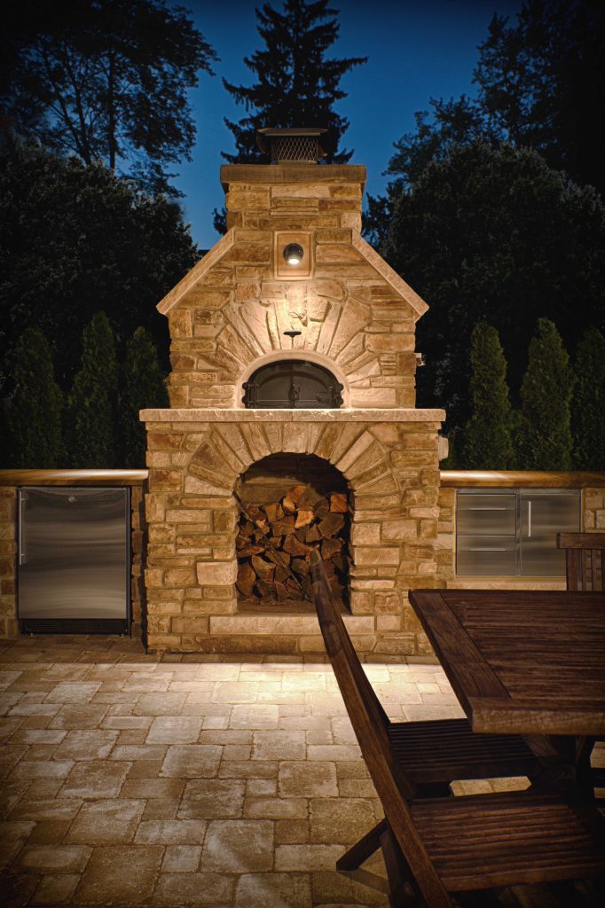 Large mountain style backyard brick patio kitchen photo in Detroit with no cover