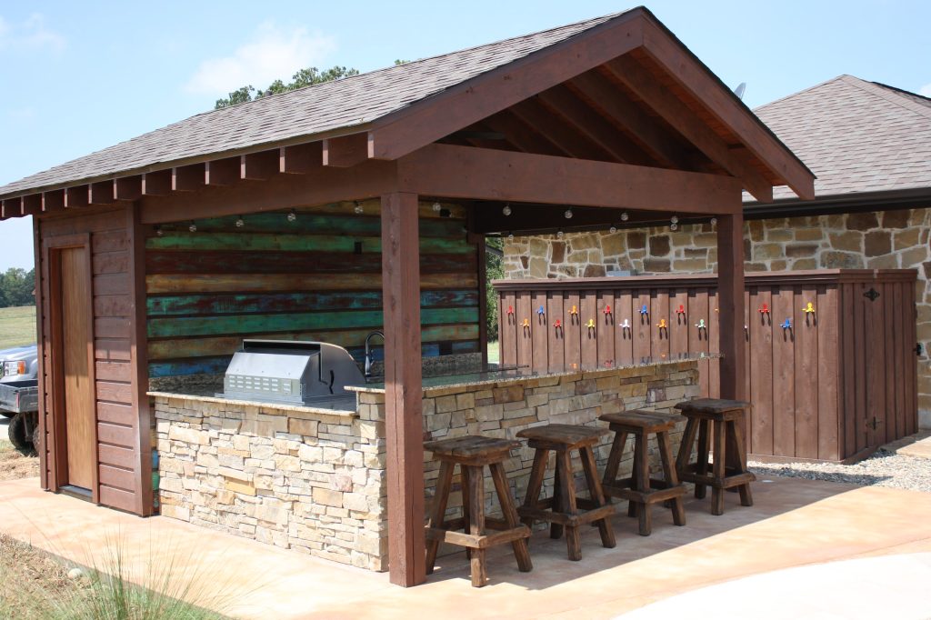 Large mountain style backyard stone patio kitchen photo in New Orleans with a gazebo