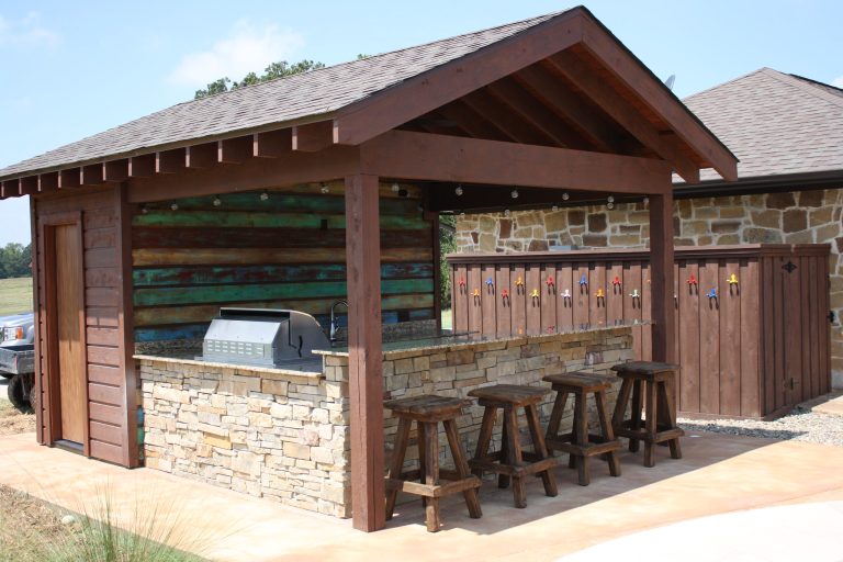Large mountain style backyard stone patio kitchen photo in New Orleans with a gazebo