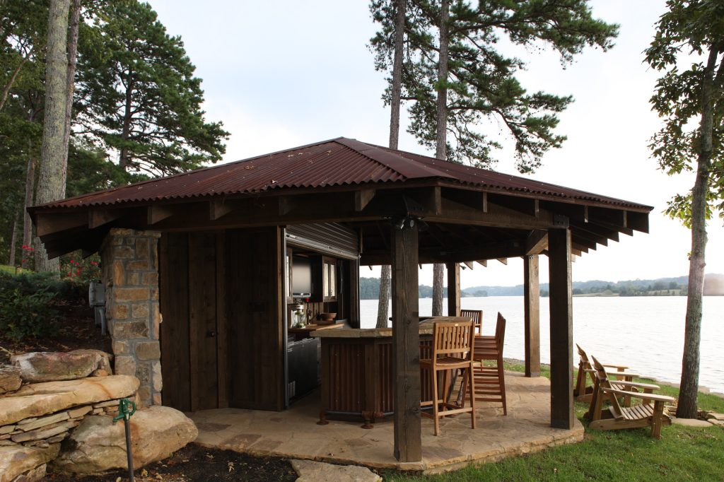Large mountain style backyard stone patio kitchen photo in Other with a gazebo