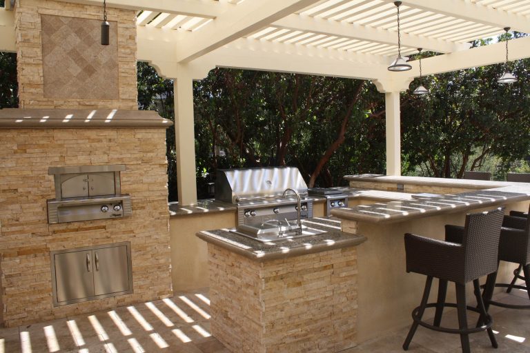 Large outdoor kitchen geared up with 42" BBQ, sink, side burner and bar top seating to serve up any pizza you'd like with the custom built-in pizza oven.